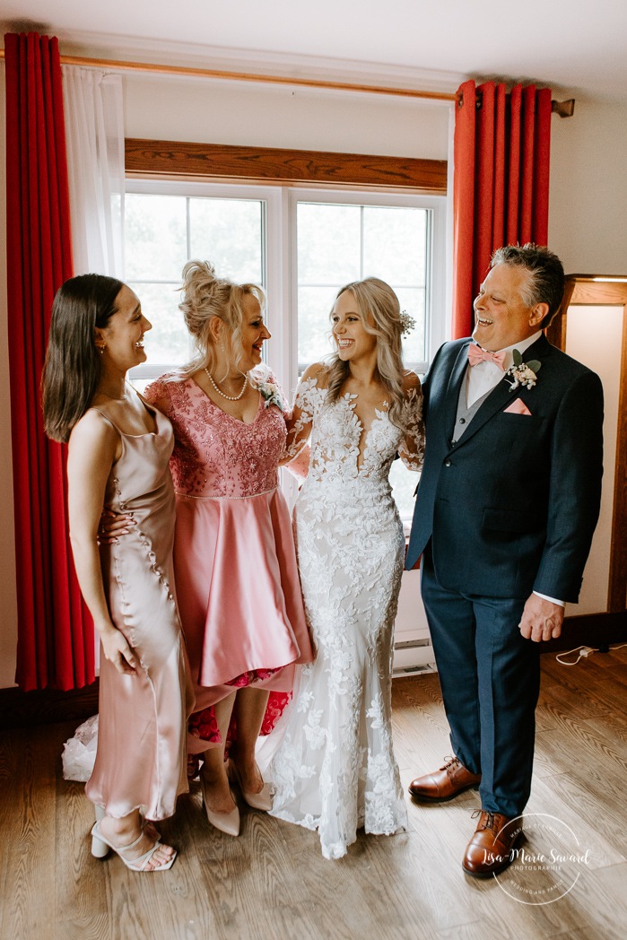 Bride with mom, dad and sister. Bride getting ready with bridesmaids in hotel room. Photographe de mariage en Mauricie. Mariage Le Baluchon Éco-Villégiature. 
