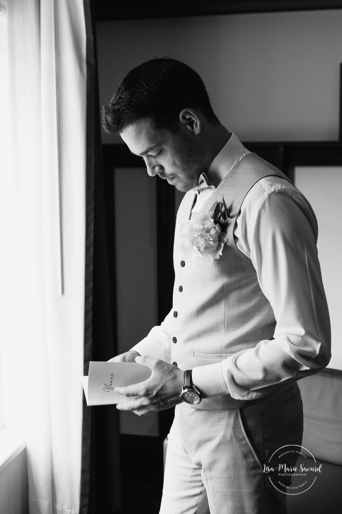 Groom reading vows before ceremony. Groom getting ready with groomsmen in hotel room. Photographe de mariage en Mauricie. Mariage Le Baluchon Éco-Villégiature. 