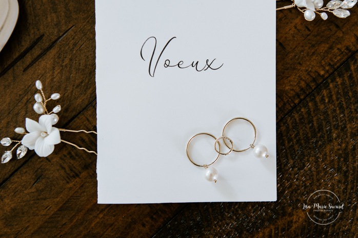 Wedding flat lay high heels perfume hair accessories earrings and vow booklet. Bride getting with bridesmaids and family at home. Mariage à la Cabane à sucre Constantin. Photographe de mariage à Montréal. Cabane à sucre Constantin wedding. Montreal wedding photographer.