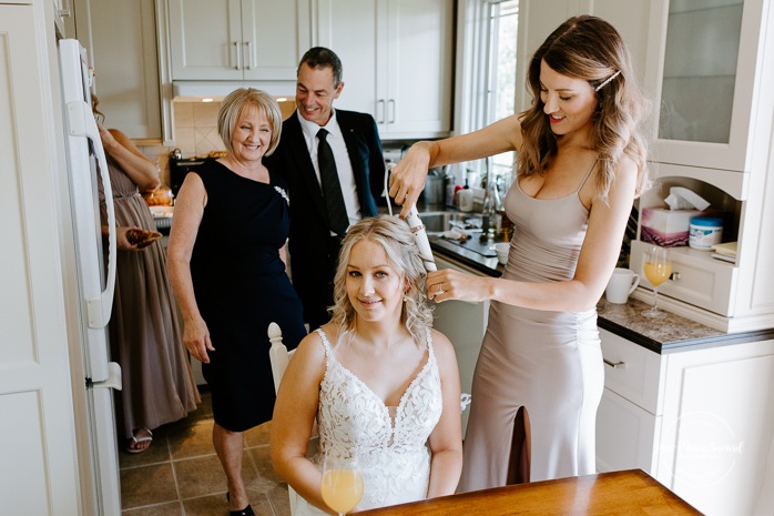 Bride getting with bridesmaids and family at home. Mariage à la Cabane à sucre Constantin. Photographe de mariage à Montréal. Cabane à sucre Constantin wedding. Montreal wedding photographer.