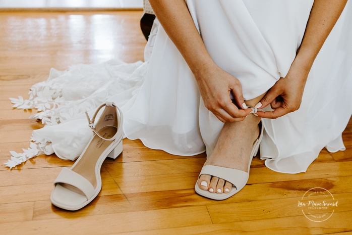 Bride putting high heel on. Bride getting with bridesmaids and family at home. Mariage à la Cabane à sucre Constantin. Photographe de mariage à Montréal. Cabane à sucre Constantin wedding. Montreal wedding photographer.