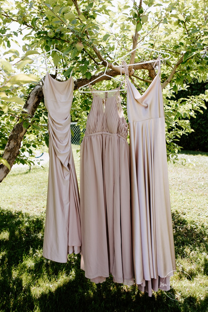 Bridesmaids dresses hanging from tree. Bride getting with bridesmaids and family at home. Mariage à la Cabane à sucre Constantin. Photographe de mariage à Montréal. Cabane à sucre Constantin wedding. Montreal wedding photographer.