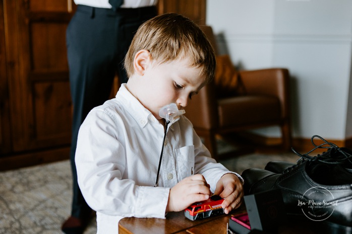Groom getting ready with toddler son and family in hotel room. Photographe de mariage à Mont-Tremblant. Mariage Le Grand Lodge Mont-Tremblant. Mont-Tremblant wedding photographer. Tremblant wedding photos.