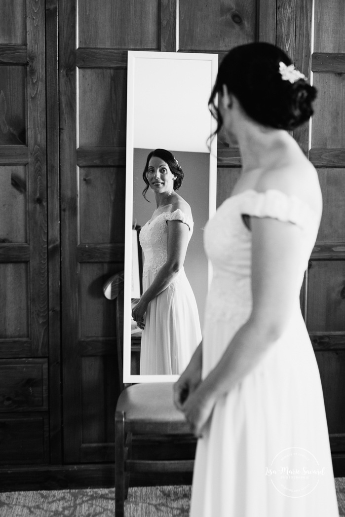 Bride looking at dress in mirror. Photographe de mariage à Mont-Tremblant. Mariage Le Grand Lodge Mont-Tremblant. Mont-Tremblant wedding photographer. Tremblant wedding photos.