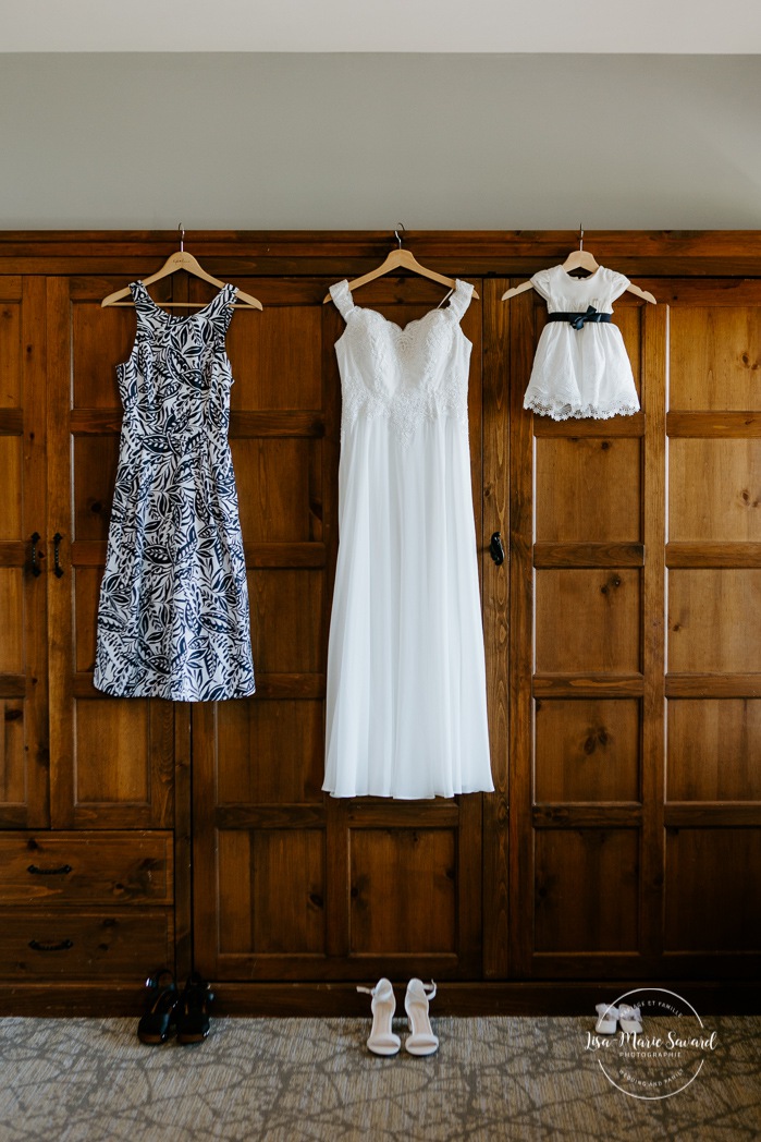 Bride, bridesmaid and flower girl dresses hanging on wall. Photographe de mariage à Mont-Tremblant. Mariage Le Grand Lodge Mont-Tremblant. Mont-Tremblant wedding photographer. Tremblant wedding photos.