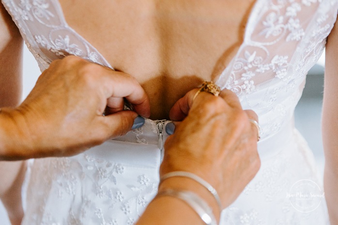 Bride putting dress on with mother. Photographe de mariage en Estrie. Photographe de mariage Cantons de l'Est. Mariage Estrimont Suites et Spa Orford.