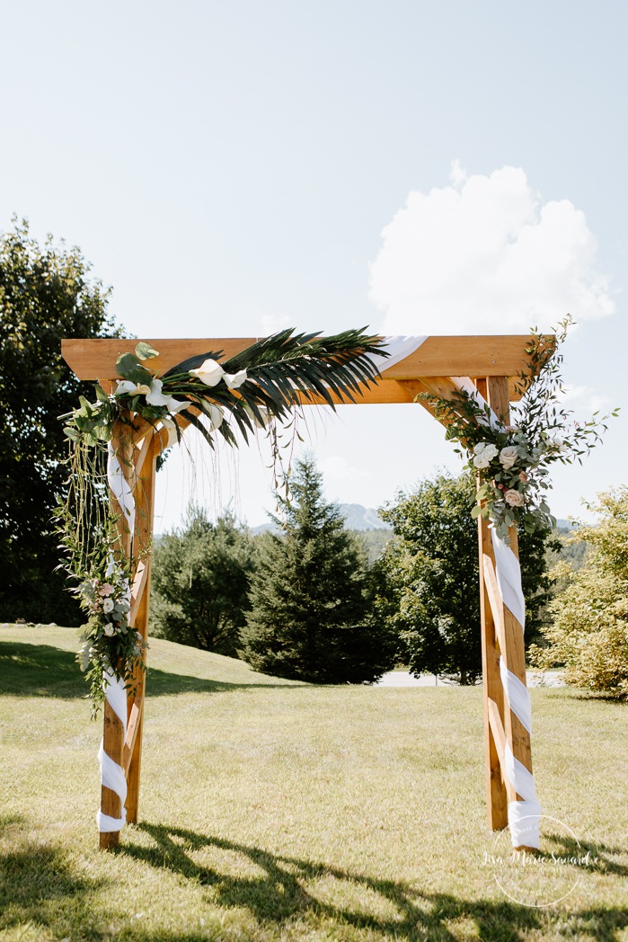 Outdoor wedding ceremony with wooden arch. Photographe de mariage en Estrie. Photographe de mariage Cantons de l'Est. Mariage Estrimont Suites et Spa Orford.