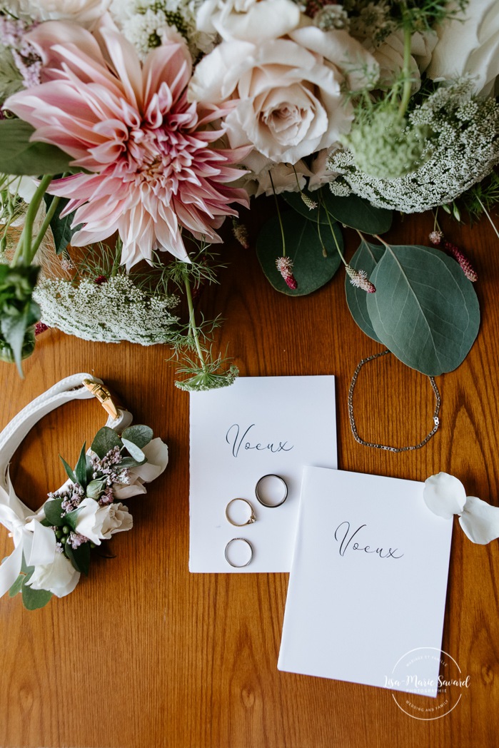 Wedding flat lay bouquet jewellery dog collar rings vow booklets. Photographe de mariage en Estrie. Photographe de mariage Cantons de l'Est. Mariage Estrimont Suites et Spa Orford.