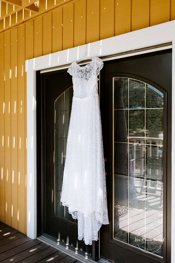 Wedding dress handing in front of front door. Photographe de mariage en Estrie. Photographe de mariage Cantons de l'Est. Mariage Estrimont Suites et Spa Orford.