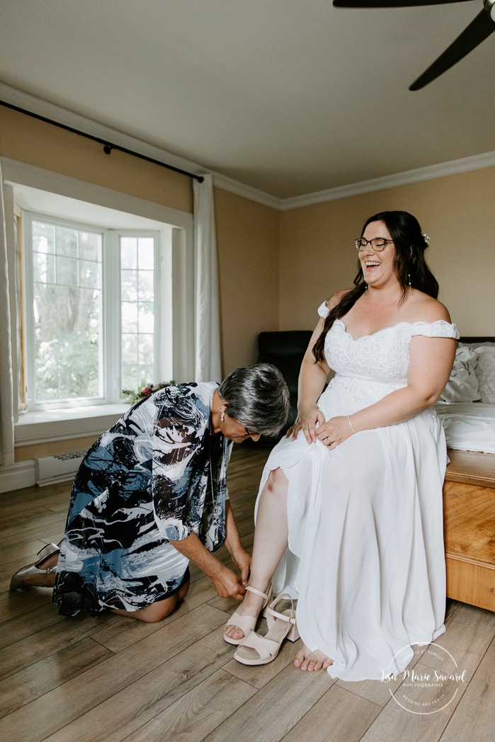 Bride getting ready with mother and daughter in bedroom. Photographe de mariage à Saint-Hyacinthe. Photographe St-Hyacinthe. Photos de mariage au Jardin Daniel A. Séguin.