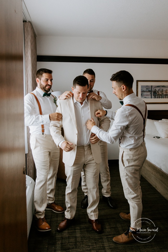 Groom getting ready with 10 groomsmen in a hotel room. Hotel Le Montagnais. Mariage à la Pulperie de Chicoutimi. Photographe de mariage au Saguenay-Lac-Saint-Jean. Photographe mariage Saguenay.