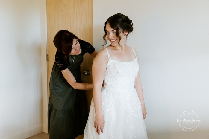 Bride getting ready with family in hotel room. Mariage à l'Auberge des Îles à Saint-Gédéon. Photographe mariage Saguenay-Lac-Saint-Jean. Photographe mariage Saguenay. 