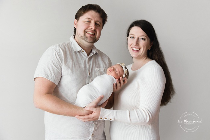 Parents holding newborn baby. Minimalist newborn photos. Clean newborn photos. Photographie de nouveau-né à Montréal. Montreal newborn photography. Séance photo bébé naissant Montréal. Montreal newborn baby photoshoot.