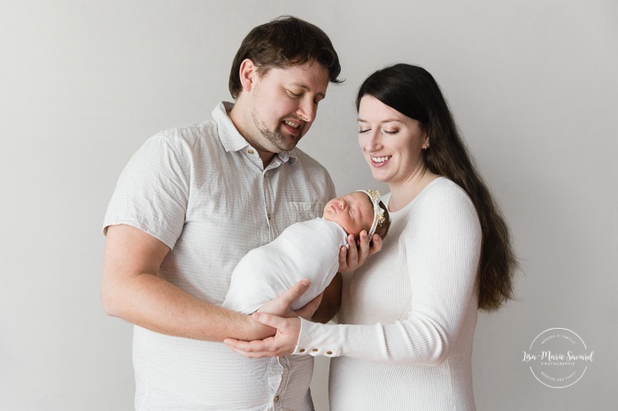 Parents holding newborn baby. Minimalist newborn photos. Clean newborn photos. Photographie de nouveau-né à Montréal. Montreal newborn photography. Séance photo bébé naissant Montréal. Montreal newborn baby photoshoot.