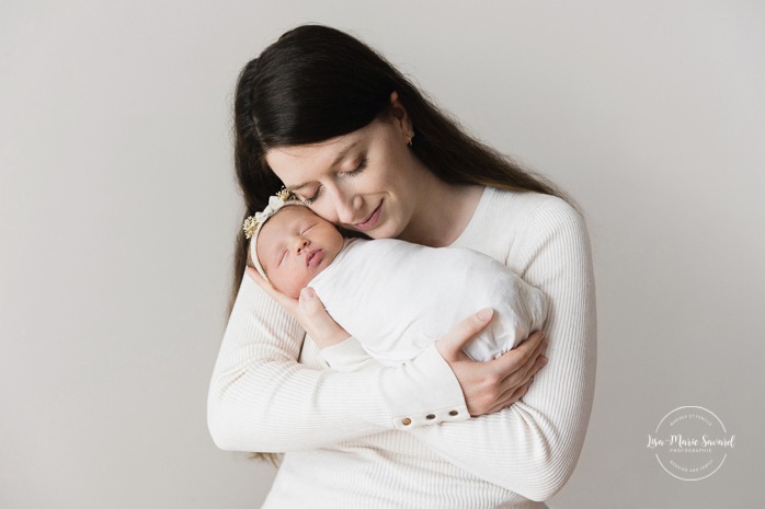 Mom holding newborn baby. Minimalist newborn photos. Clean newborn photos. Photographie de nouveau-né à Montréal. Montreal newborn photography. Séance photo bébé naissant Montréal. Montreal newborn baby photoshoot.