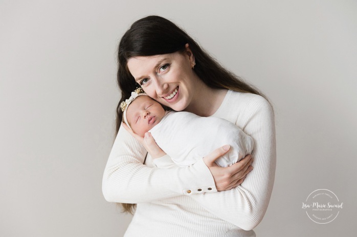 Mom holding newborn baby. Minimalist newborn photos. Clean newborn photos. Photographie de nouveau-né à Montréal. Montreal newborn photography. Séance photo bébé naissant Montréal. Montreal newborn baby photoshoot.