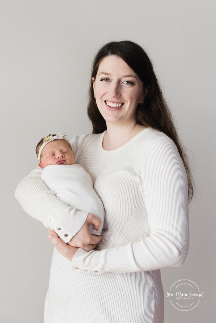 Mom holding newborn baby. Minimalist newborn photos. Clean newborn photos. Photographie de nouveau-né à Montréal. Montreal newborn photography. Séance photo bébé naissant Montréal. Montreal newborn baby photoshoot.