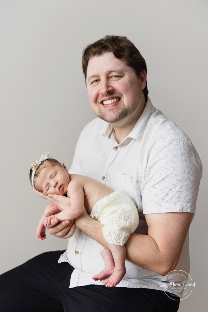 Dad holding newborn baby. Minimalist newborn photos. Clean newborn photos. Photographie de nouveau-né à Montréal. Montreal newborn photography. Séance photo bébé naissant Montréal. Montreal newborn baby photoshoot.