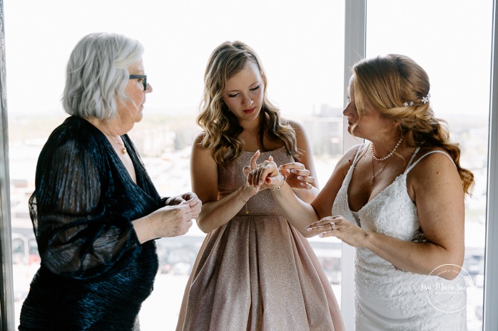 Bride getting ready with mother and daughter in hotel room. Mariage Grand Times Hotel Laval. Mariage à Laval. Laval Grand Times Hotel wedding. Laval wedding photographer.