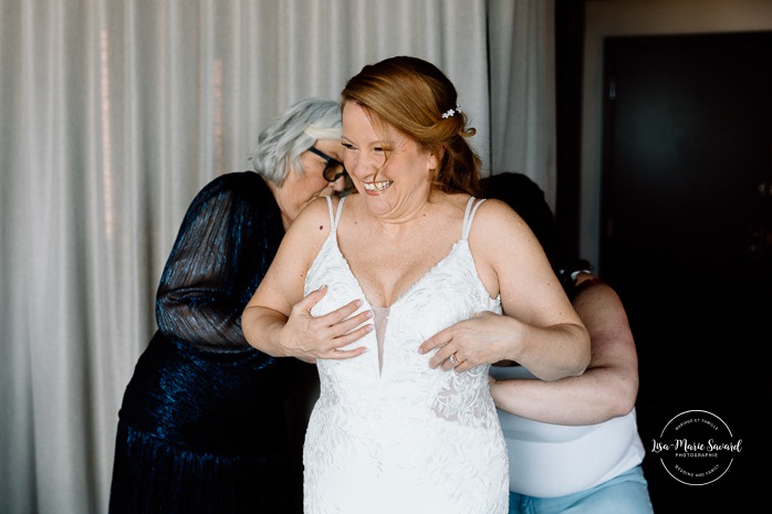 Bride getting ready with bridesmaids in hotel room. Mariage Grand Times Hotel Laval. Mariage à Laval. Laval Grand Times Hotel wedding. Laval wedding photographer.