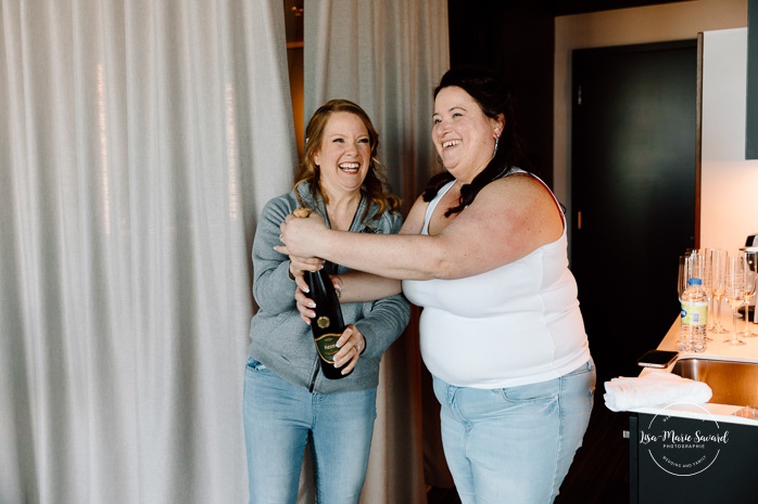 Bride getting ready with bridesmaids in hotel room. Mariage Grand Times Hotel Laval. Mariage à Laval. Laval Grand Times Hotel wedding. Laval wedding photographer.