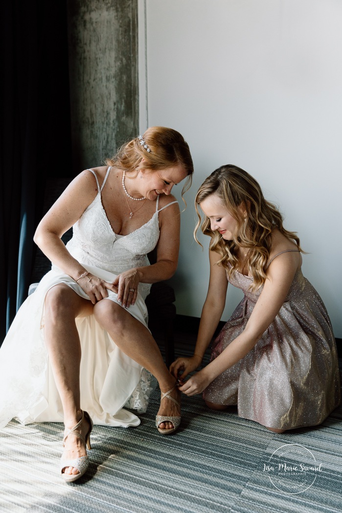 Bride getting ready with mother and daughter in hotel room. Mariage Grand Times Hotel Laval. Mariage à Laval. Laval Grand Times Hotel wedding. Laval wedding photographer.