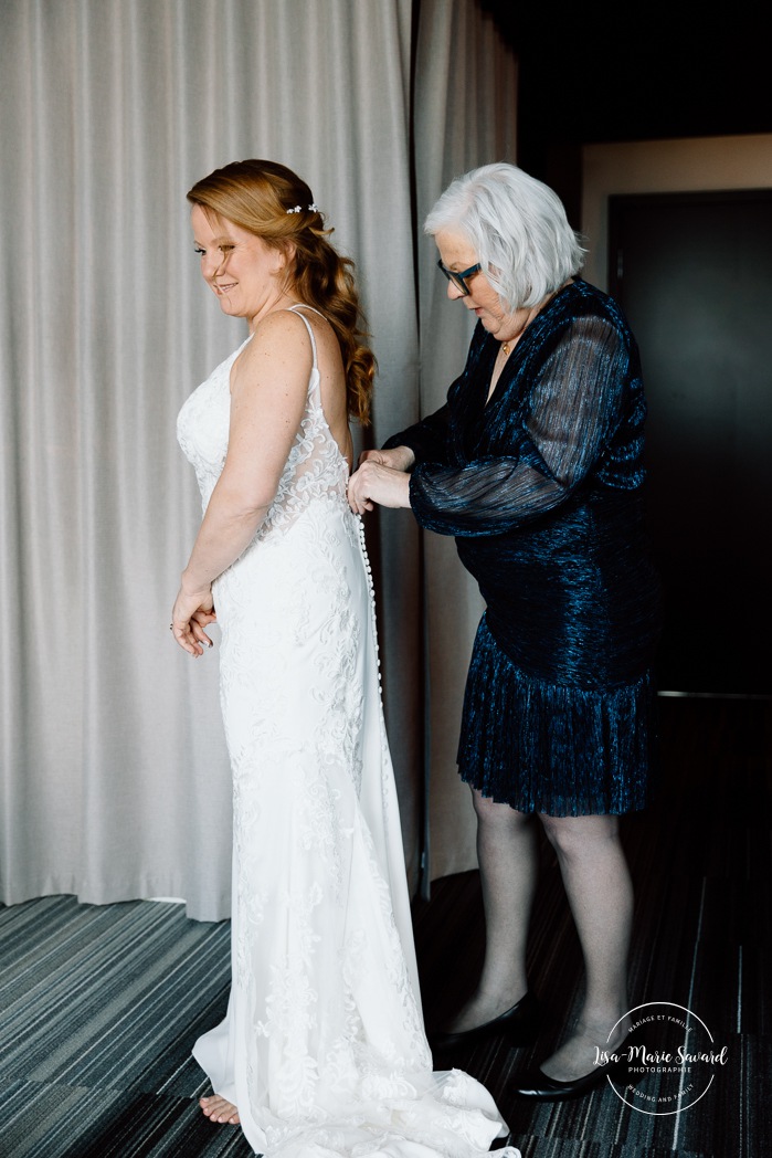 Bride getting ready with bridesmaids in hotel room. Mariage Grand Times Hotel Laval. Mariage à Laval. Laval Grand Times Hotel wedding. Laval wedding photographer.