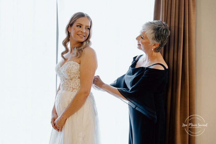 Bride getting ready with bridesmaids in hotel room. Mariage Hôtel Rive-Gauche Beloeil. Photographe mariage à Montréal. Montreal wedding photographer.