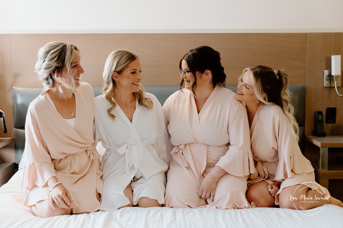 Bride getting ready with bridesmaids in hotel room. Mariage Hôtel Rive-Gauche Beloeil. Photographe mariage à Montréal. Montreal wedding photographer.