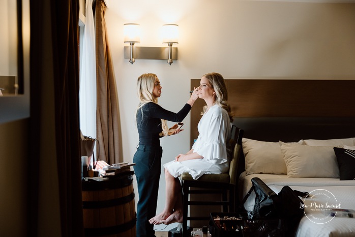 Bride getting ready with bridesmaids in hotel room. Mariage Hôtel Rive-Gauche Beloeil. Photographe mariage à Montréal. Montreal wedding photographer.