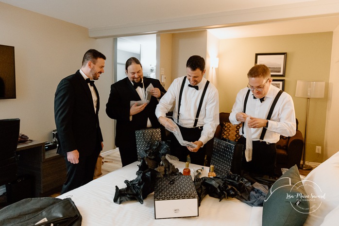 Groom getting ready with groomsmen in hotel room. Mariage Hôtel Rive-Gauche Beloeil. Photographe mariage à Montréal. Montreal wedding photographer.