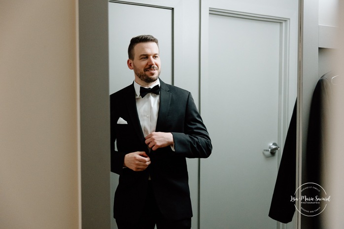 Groom getting ready with groomsmen in hotel room. Mariage Hôtel Rive-Gauche Beloeil. Photographe mariage à Montréal. Montreal wedding photographer.