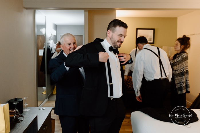 Groom getting ready with groomsmen in hotel room. Mariage Hôtel Rive-Gauche Beloeil. Photographe mariage à Montréal. Montreal wedding photographer.