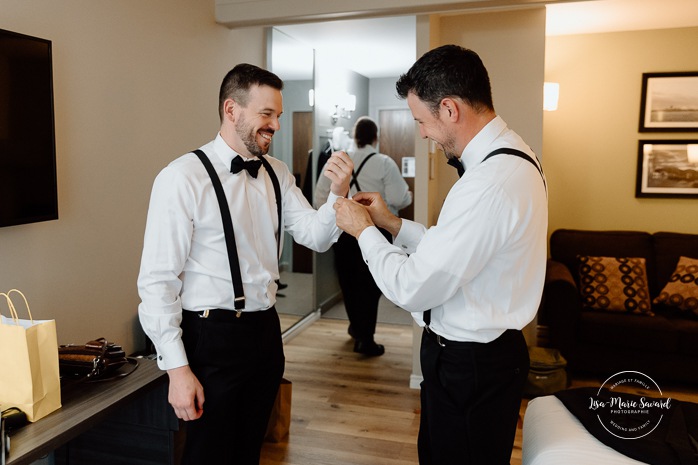 Groom getting ready with groomsmen in hotel room. Mariage Hôtel Rive-Gauche Beloeil. Photographe mariage à Montréal. Montreal wedding photographer.