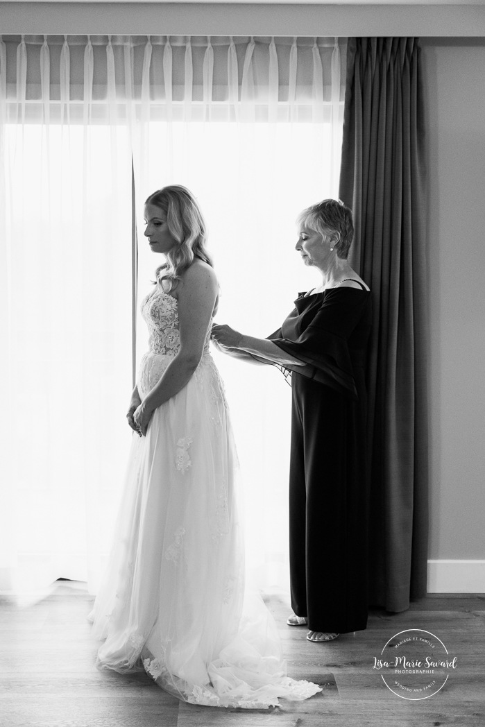 Bride getting ready with bridesmaids in hotel room. Mariage Hôtel Rive-Gauche Beloeil. Photographe mariage à Montréal. Montreal wedding photographer.