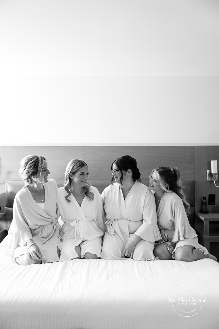 Bride getting ready with bridesmaids in hotel room. Mariage Hôtel Rive-Gauche Beloeil. Photographe mariage à Montréal. Montreal wedding photographer.