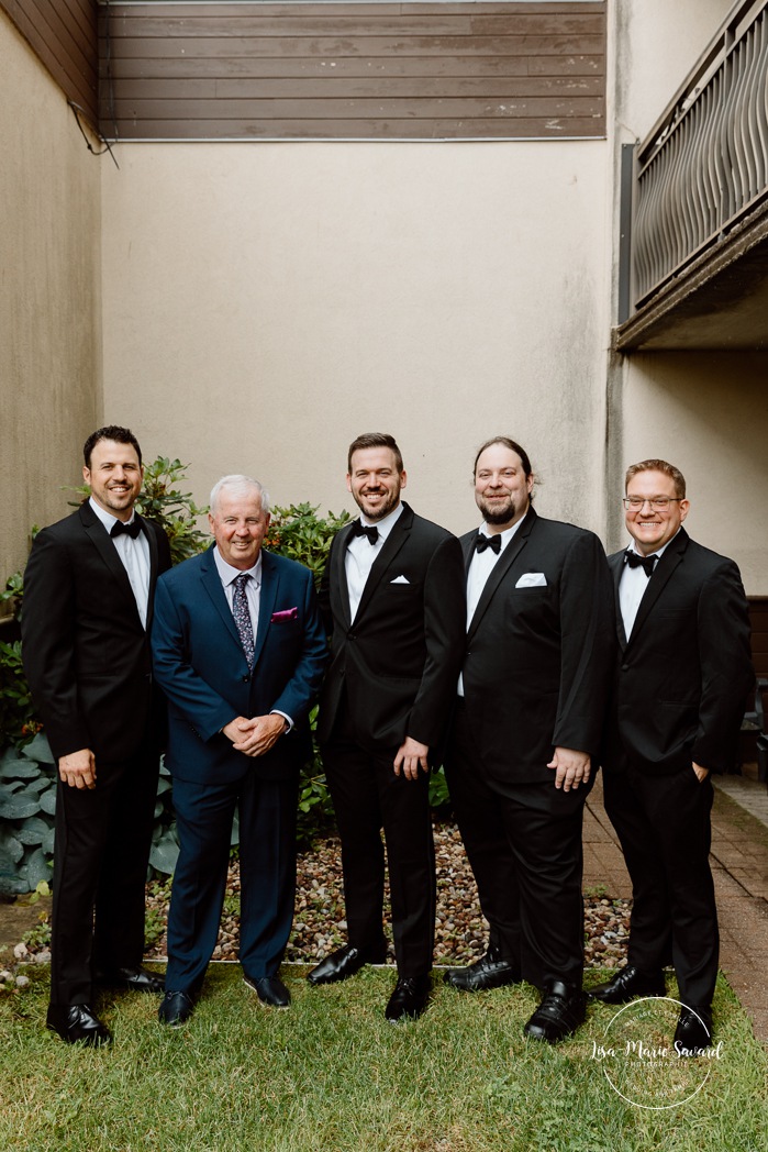 Groom getting ready with groomsmen in hotel room. Mariage Hôtel Rive-Gauche Beloeil. Photographe mariage à Montréal. Montreal wedding photographer.