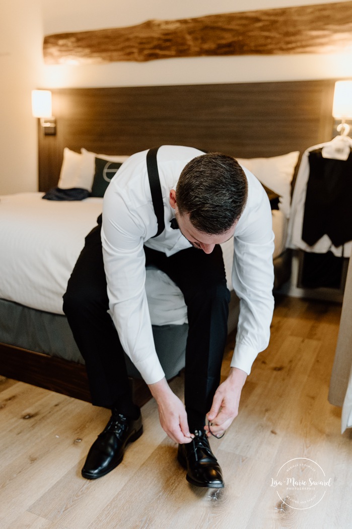 Groom getting ready with groomsmen in hotel room. Mariage Hôtel Rive-Gauche Beloeil. Photographe mariage à Montréal. Montreal wedding photographer.