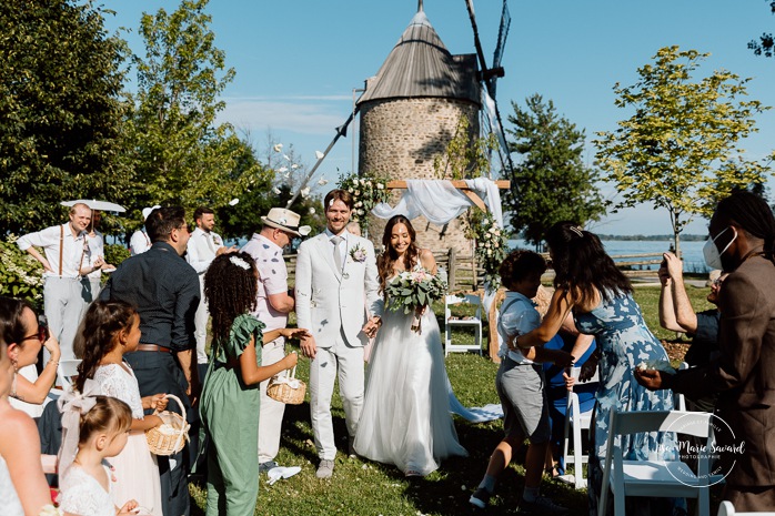 Outdoor wedding ceremony in front of windmill. Mariage à la Pointe-du-Moulin. Photographe mariage à Montréal. Pointe-du-Moulin wedding. Montreal wedding photographer.