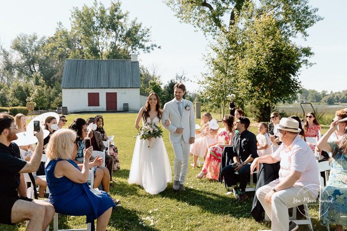 Outdoor wedding ceremony in front of windmill. Mariage à la Pointe-du-Moulin. Photographe mariage à Montréal. Pointe-du-Moulin wedding. Montreal wedding photographer.