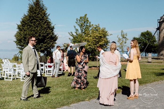 Outdoor wedding ceremony in front of windmill. Mariage à la Pointe-du-Moulin. Photographe mariage à Montréal. Pointe-du-Moulin wedding. Montreal wedding photographer.