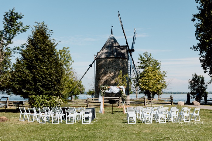 Outdoor wedding ceremony in front of windmill. Mariage à la Pointe-du-Moulin. Photographe mariage à Montréal. Pointe-du-Moulin wedding. Montreal wedding photographer.