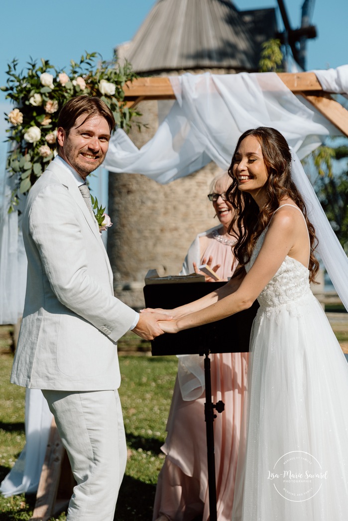 Outdoor wedding ceremony in front of windmill. Mariage à la Pointe-du-Moulin. Photographe mariage à Montréal. Pointe-du-Moulin wedding. Montreal wedding photographer.