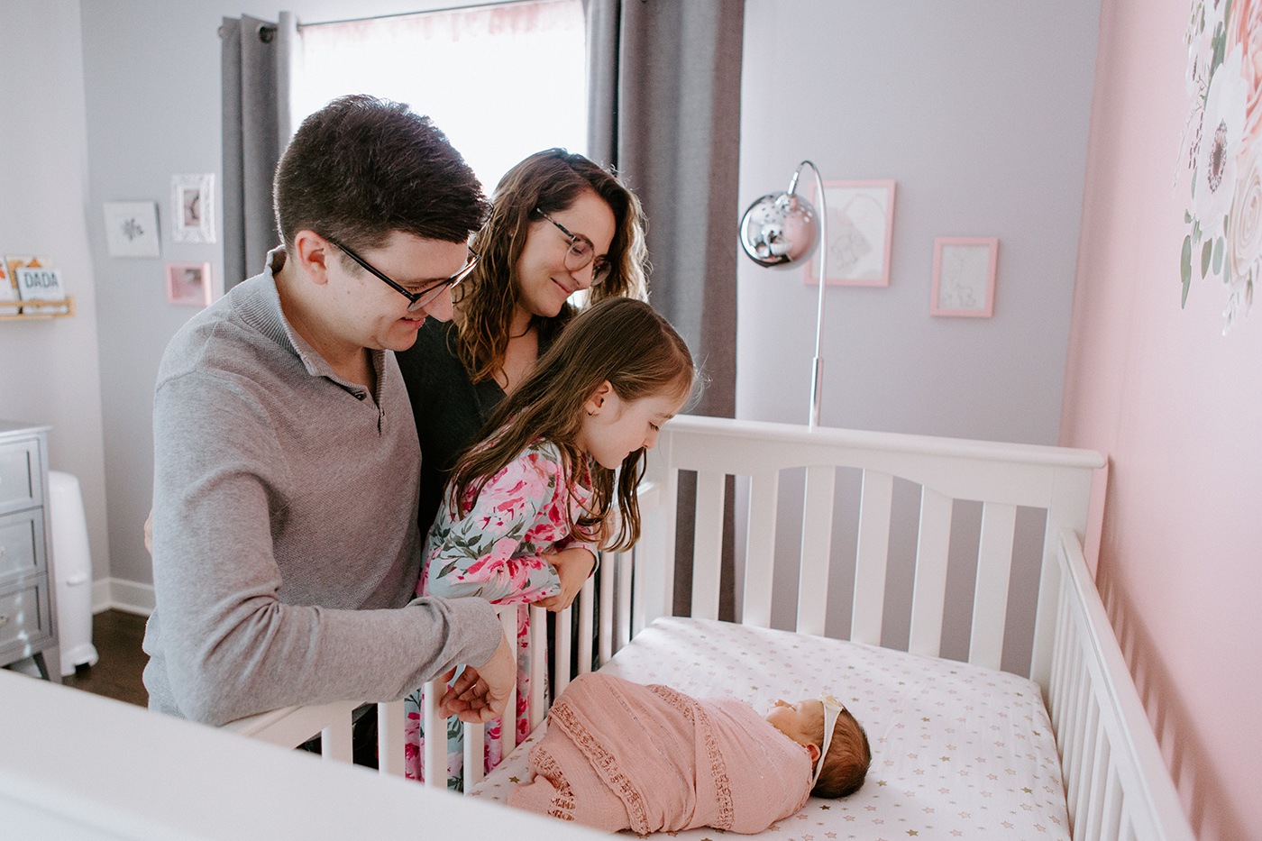 Lifestyle newborn session with big sister. Parents and sister looking at baby in crib. Séance nouveau-né à Saint-Bruno-de-Montarville. Photographe de famille en Montérégie. Montreal South Shore family photographer. Montreal lifestyle newborn photographer.