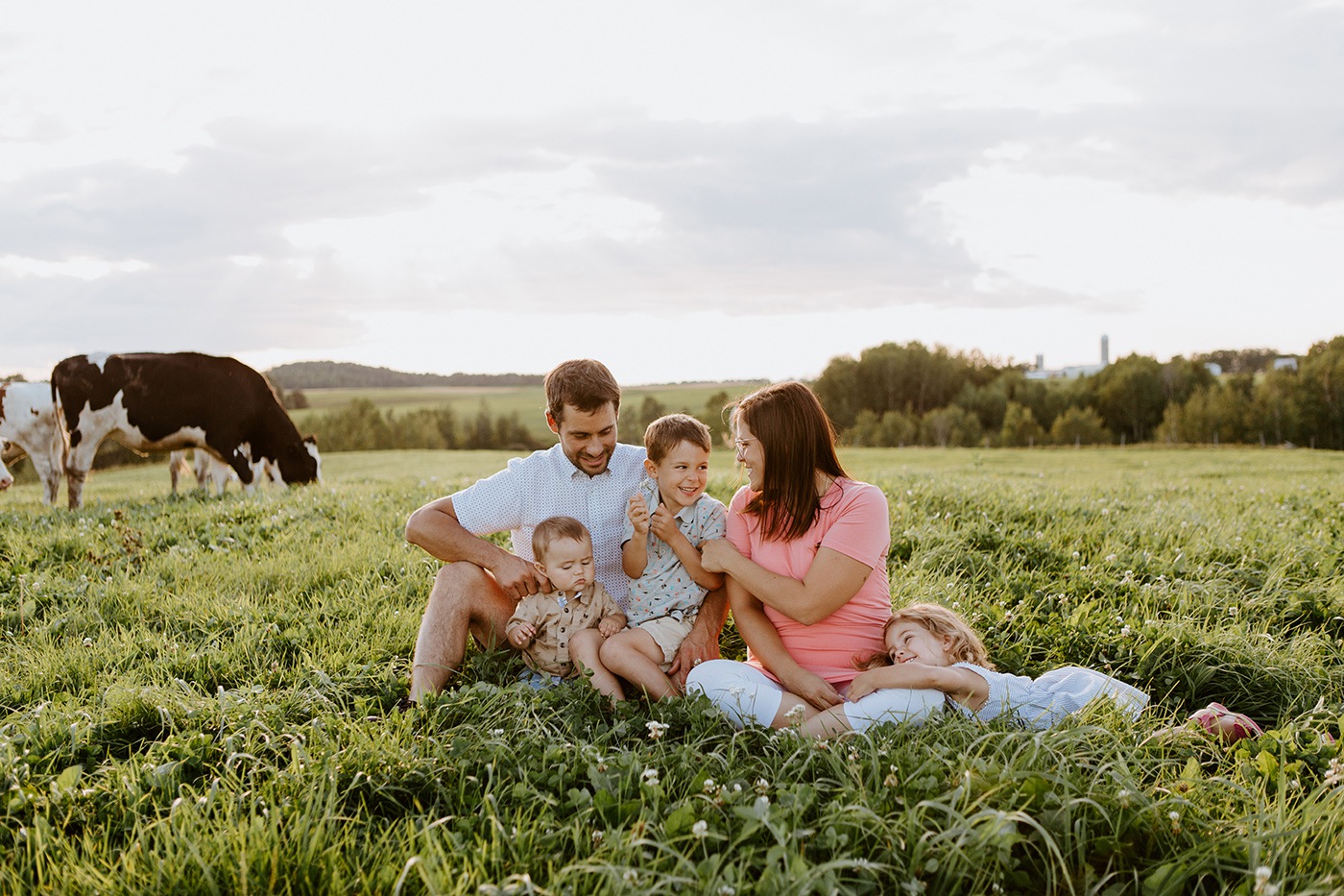 Dairy farm photos with cows. Farm photo session. Family photos with cows. Countryside family photos. Séance photo à la ferme avec des vaches. Séance photo ferme laitière. Photographe de famille à Montréal. Montreal family photographer.