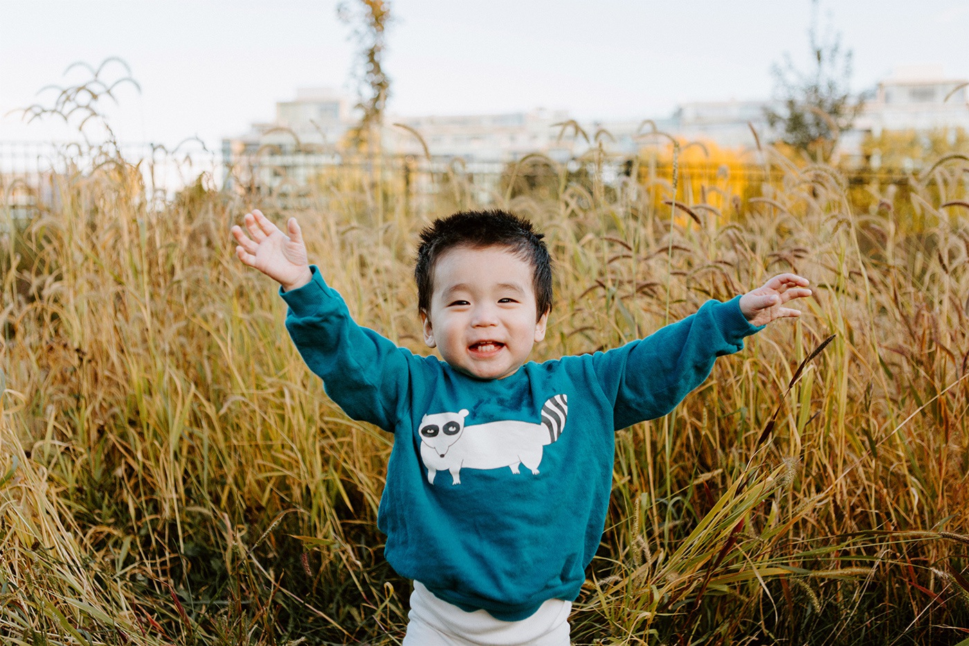 Fall family photos. Fall family session. Baby boy playing with tall grass. Korean family photos. Séance photo le long du Canal Lachine. Lachine Canal photoshoot. Photos de famille Canal Lachine. Lachine Canal family photos. Photographe de famille à Montréal. Montreal family photographer.