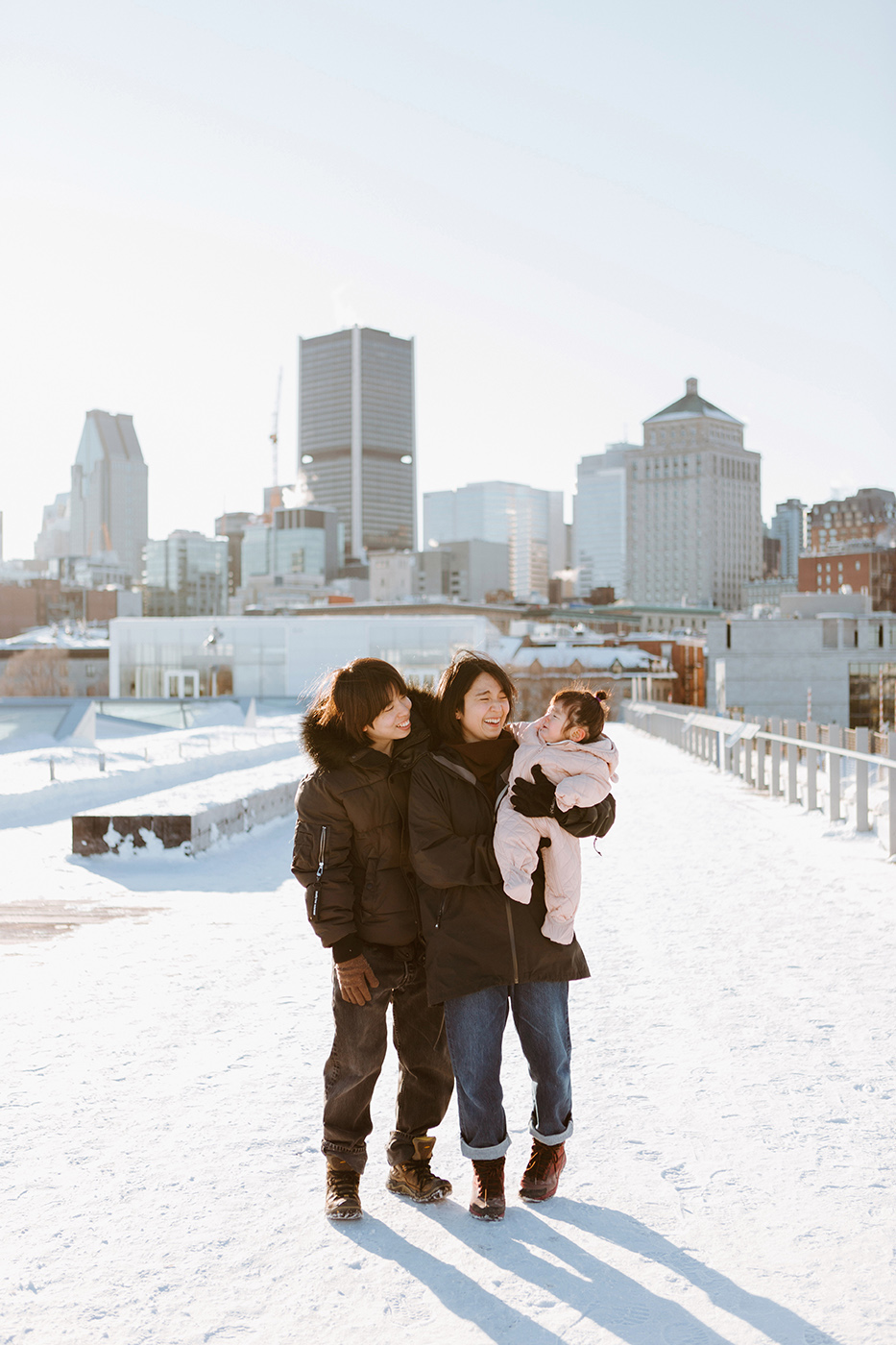 Winter family session. Family photos in the snow. Asian family photos. Séance photo dans le Vieux-Port de Montréal. Photos de famille à Montréal. Grand Quai de Montréal. Promenade d'Iberville. Old Port of Montreal photo session. Montreal family photos.