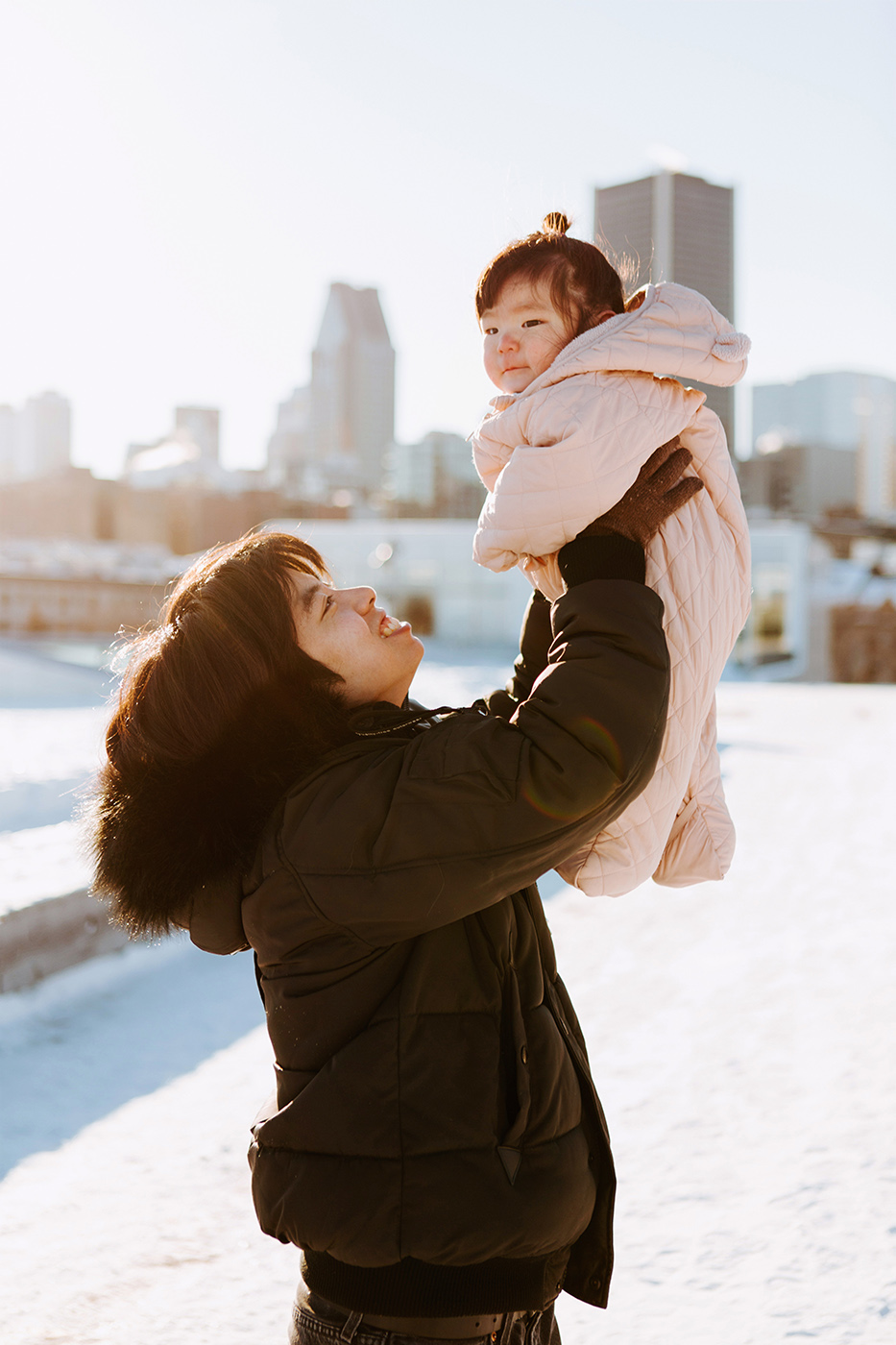 Winter family session. Family photos in the snow. Asian family photos. Séance photo dans le Vieux-Port de Montréal. Photos de famille à Montréal. Grand Quai de Montréal. Promenade d'Iberville. Old Port of Montreal photo session. Montreal family photos.