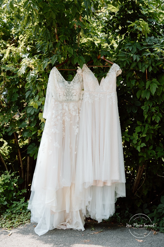 Same sex wedding photos. Lesbian wedding photos. Two brides wedding photos. Two wedding dresses hanging on a tree. Mariage au Verger Jude-Pomme. Photographe mariage LGBTQ+ à Montréal. Montreal LGBTQ+ wedding photographer. 