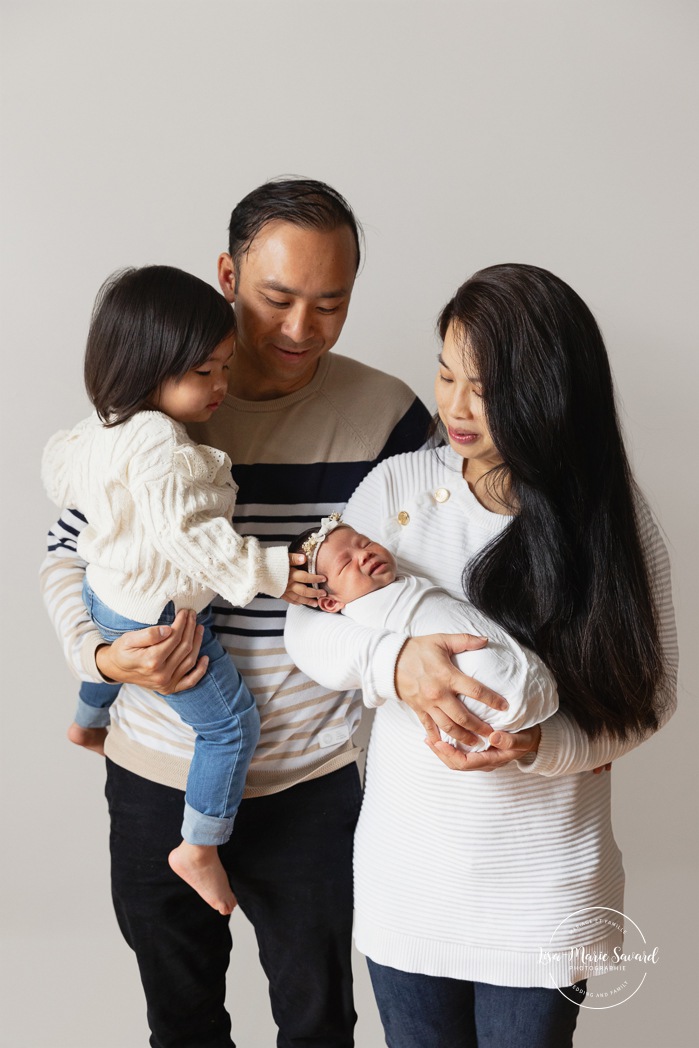 Minimalist newborn photos. In-studio newborn photos. Newborn photos with parents. Newborn photos big sister. Séance nouveau-né en studio à Montréal. Photographe nouveau-né Montréal. Montreal in-studio newborn photos. Montreal newborn photographer.